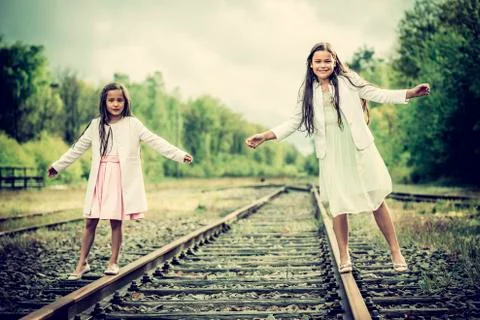 Two sisters walking on a rail Photos