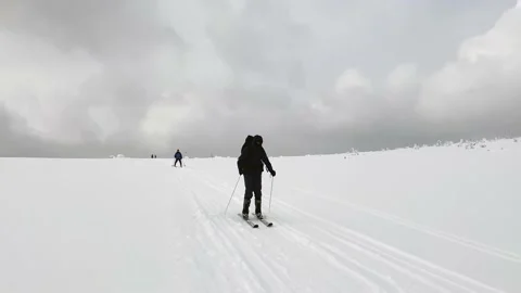 Two skiers are skiing down a small snowy slope Video stock 179347902