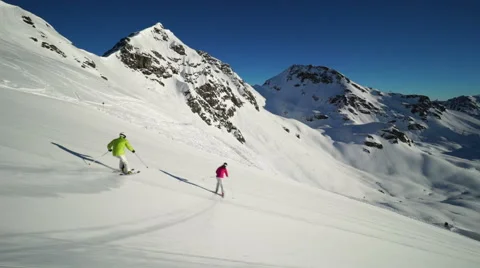 Two skiers carving on empty ski piste Stock Footage 46993988