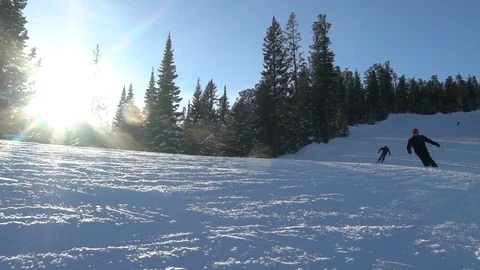 Two skiers skiing slope on winter day Stock Footage 71880321