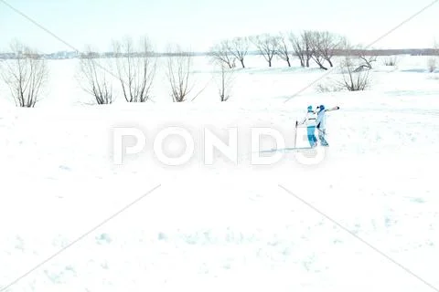 Two skiers walking in desert winter field Stock Photos