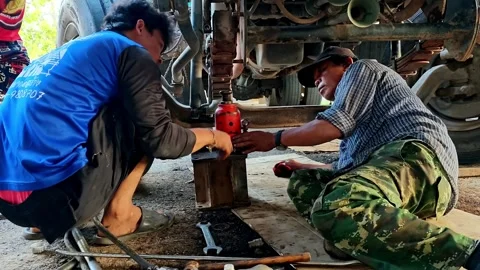 Two skilled mechanics conducting maintenance work on a truck inside a well Stock Footage 340583124
