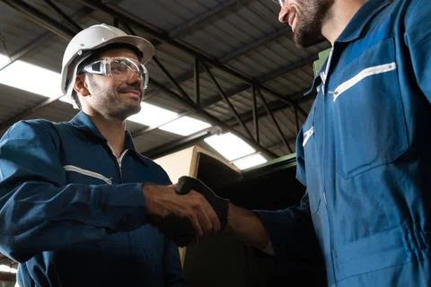 Two skillful factory engineer or worker showing teamwork and partnership . Fotos Stock