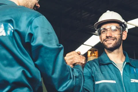 Two skillful factory engineer or worker showing teamwork and partnership . Stock Photos
