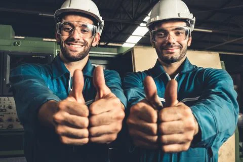 Two skillful factory engineer or worker showing teamwork and partnership . Stock Photos