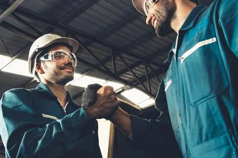 Two skillful factory engineer or worker showing teamwork and partnership . Stock Photos