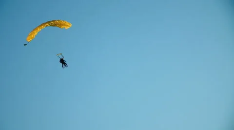 Two sky divers with a yellow parachute are landing Stock Footage 55343728