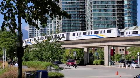 Two sky trains moving in opposite direction, downtown Vancouver, sunny day Stock Footage 51558838