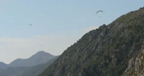 Two skydivers with parachutes flying above big mountain, parachutists in action. Vidéo 93897553