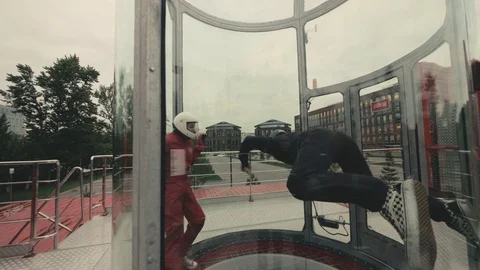 Two skydivers train in wind tunnel. Skydiver flies in wind tube. Sky diving Stock Footage 77152940
