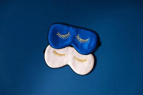 Two sleeping masks on blue background, concept of rest, quality of sleep, g.. Stock Photos