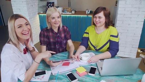 Two slender blondes, one plump brunette-communicate casually in a cafe Stock Footage 78129613