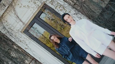 Two slender girlfriends in white and blue linen shorts. Video stock 151068437