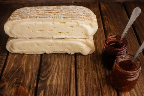 Two Slice of Crafted Brie Cheese with Honey on Wooden Brown Background with F Photos