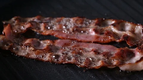 Two Slices Of Bacon Frying On Grill Pan Stock Footage 90965687