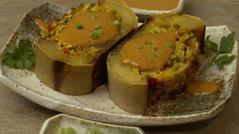Two slices of baked stuffed squash poured with sauce. Stock Footage 331290284