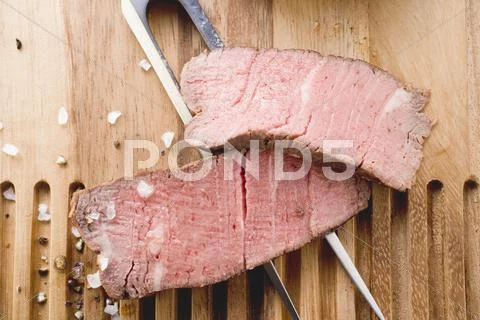 Two slices of beef steak on carving fork Stock Photos