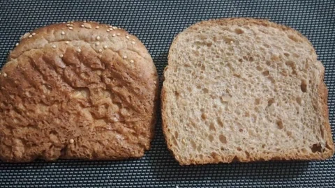 Two slices of fresh whole grain bread in motion video footage Stock Footage 339249049