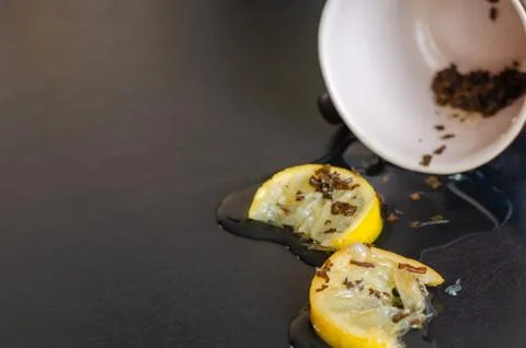 Two slices of lemon in a small pool of tea on the table. Stock Photos