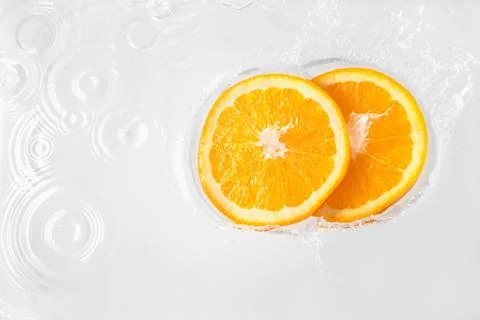 Two slices of orange floating in liquid Foto stock