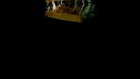 Two slices of pineapple falling underwater on a black background 스톡 동영상 126766053