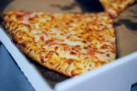 Two Slices of Plain Cheese Pizza in an Open Greasy White Cardboard Box Фото