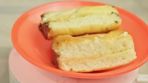 Two slices of sweet bread with melted chocolate filling rotating on an oran.. Video stock 323571912