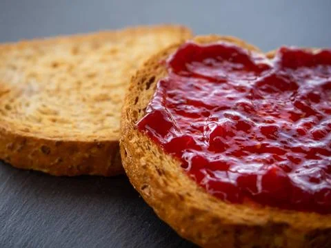  Two slices of toast with raspberry jam on a slate plate Two slices of toa... Stock Photos