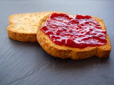  Two slices of toast with raspberry jam on a slate plate Two slices of toa... Stock Photos