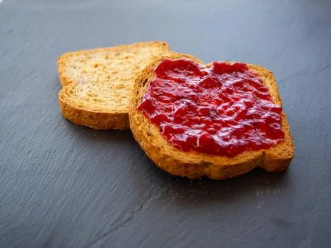  Two slices of toast with raspberry jam on a slate plate Two slices of toa... Stock Photos