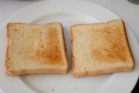 Two slices of toasted bread on a white plate Fotos de archivo