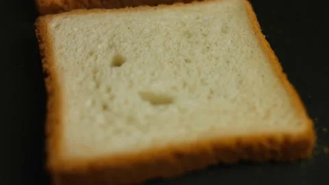 Two slices of toasts cooked in a pan on the stove. Cooking delicious toasts at Stock Footage 150497575