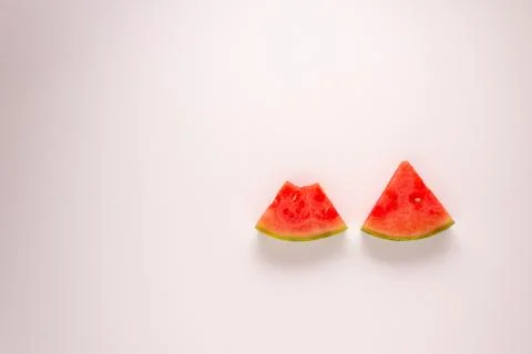 Two slices of water melon with a bite take out of one against a white background Stock-Fotos