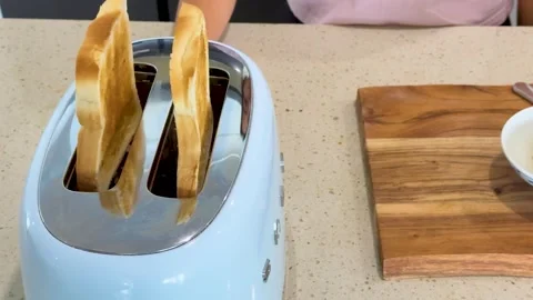 Two slices of white bread popping up from retro blue toaster in slow motion.. Stock Footage 333936950
