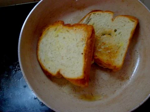 Two slices of white bread toasted on a griddle Stock-Fotos