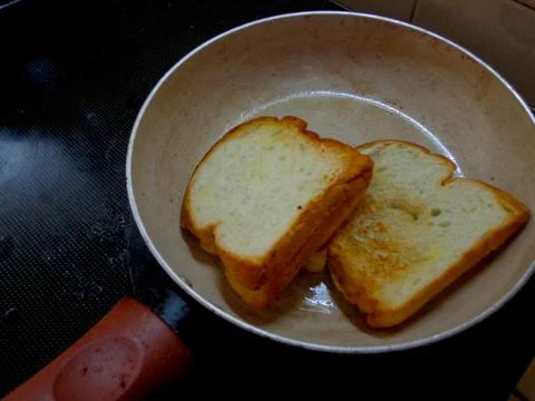 Two slices of white bread toasted on a griddle 스톡 사진
