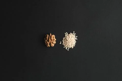 Two slides of half of walnut and white sesame Stock Photos