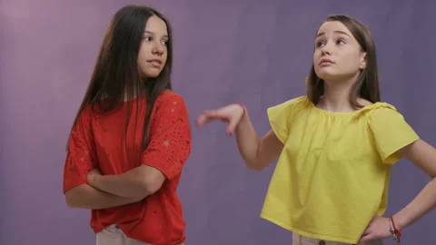 Two slim long-haired girls dancing happily, wearing light yellow and red t Stock Footage 129341853