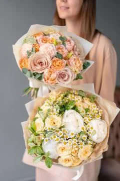 Two Small Beautiful bouquets of mixed flowers in woman hand. Floral shop concept Foto stock