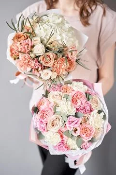 Two Small Beautiful bouquets of mixed flowers in woman hand. Floral shop concept Stock Photos