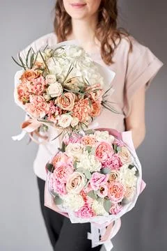 Two Small Beautiful bouquets of mixed flowers in woman hand. Floral shop concept Stock Photos
