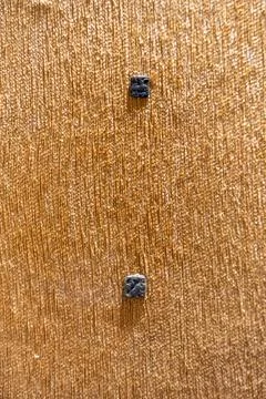 Two small black objects are on a brown surface. in Chennai Stock Photos