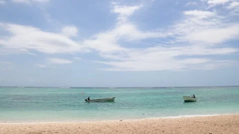 Two small boats gently float on the shimmering turquoise waters, meeting a Stock Footage 319476701