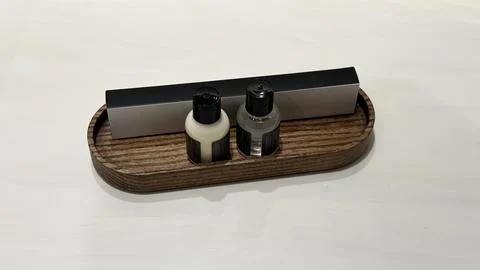 Two small bottles with black caps and a rectangular box placed on an oval wooden Stock Photos