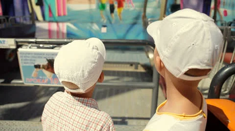 Two small boys stand near the ferris wheel Stock Footage 25856629