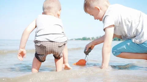 Two Small Brothers Playing with each other on Beach in Water on a Sunny Day.  Stock Footage 133937893
