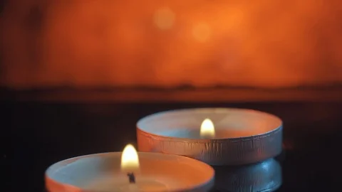 Two small candles floating in the water in the darkness, warm tones Stockbeeldmateriaal 114066685