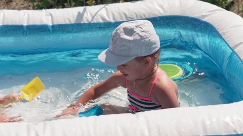 Two small children boy and girl swim in pool in summer, splashing water. Video stock 138056058