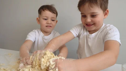 Two small children prepare something from the dough. A two boys are sitting at Video stock 128826272