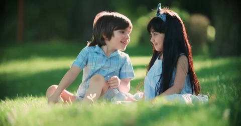 Two small children,Caucasian boy and Asian girl having fun in the Park ,slow Stock Footage